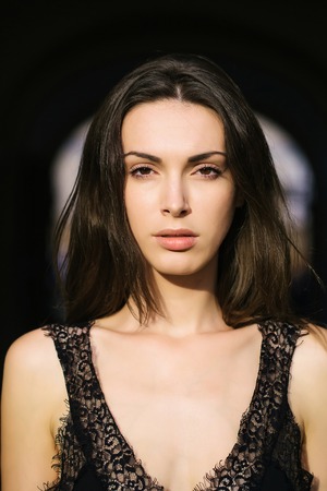 young sexy sensual woman or girl portrait with long brunette hair and pretty face in black vest...