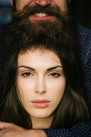 Pretty girl young woman with brown eyes brunette hair and graying beard of smiling man on headの写真素材