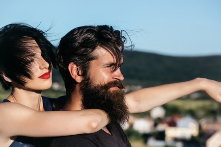 Pretty girl young beautiful woman with red lips and short brunette hair hugs handsome man hipster...
