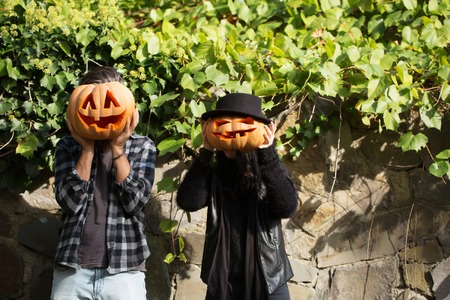 young halloween couple of bearded man with beard and mustache and girl in black witch hat near stony...