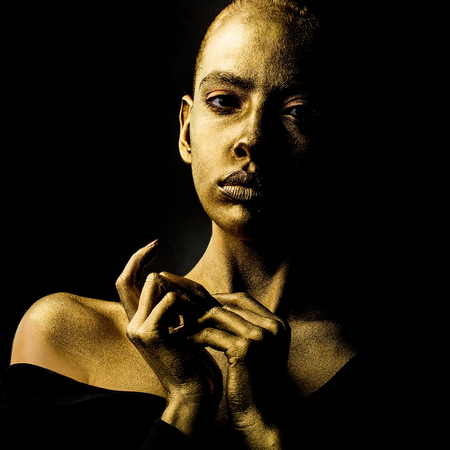 sexy golden woman or girl has pretty face with makeup and body art metallized color, closeupの写真素材