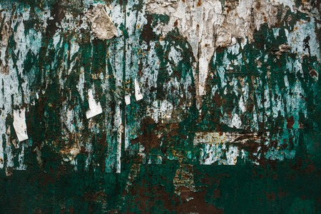 old metal rusty abstract wall with bunch of ads that hang on it and worn green paintの写真素材