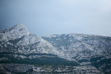 Beautiful mountain ranges with high peaks natural elevation of earth surface on blue sky backgroundの写真素材