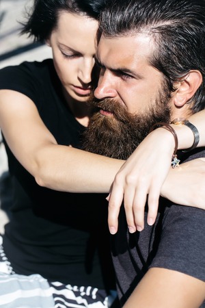 Young couple of beautiful brunette woman and handsome man hipster with beard hug outdoors on sunny dayの写真素材
