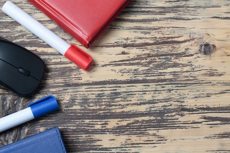 Two markers red and blue diaries and black computer mouse business supplies on wooden background copy spaceの写真素材