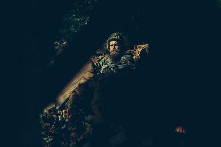 Bearded soldier behind the barricade guards the territoryの写真素材