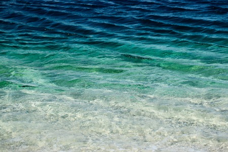 blue sea or ocean water foaming waves rolled on pebble coast as natural background with nobody
