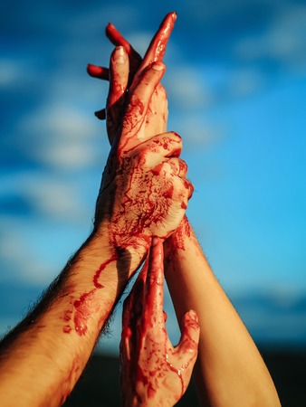 zombie hands male and female of man war soldier and girl woman with bloody wounds and red blood on skin on blue sky backgroundの写真素材