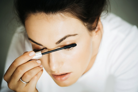 young cute sexy woman or girl portrait with pretty face and brunette hair dyeing eyelashes with...
