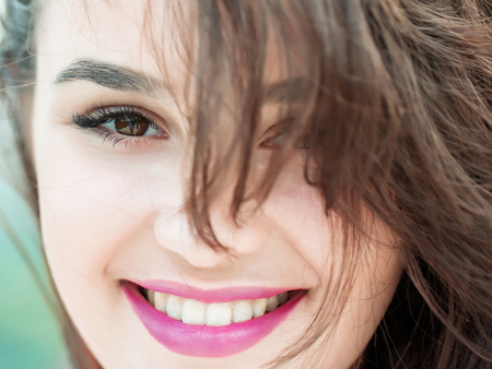 Young woman brunette with pretty cute smiling face hazel eyes fashion natural makeup pink lips and perfect healthy skinの写真素材