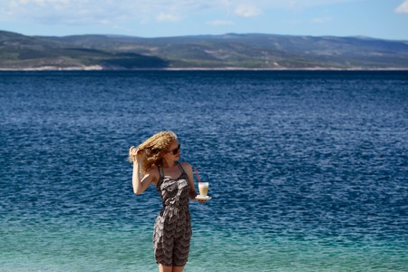 young pretty sexy cute girl or woman with curly blonde hair in summer dress with coffee glass sunny...