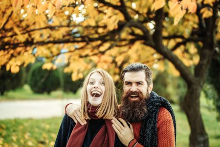 Young couple of pretty girl and bearded man hipster outdoors in autumn park with yellow leaves on natural backgroundの写真素材