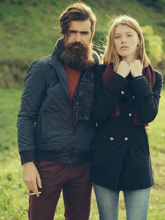 Young couple of pretty girl and bearded man hipster outdoors in park on autumn day on natural backgroundの写真素材