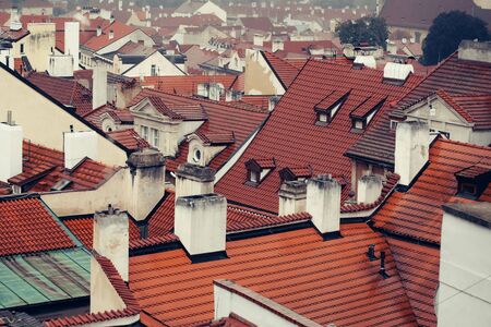 Terracotta tiled roofs with chimneys and dormer windows of city or town houses buildings on roofscape backgroundの写真素材