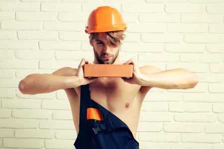 young handsome bearded macho man builder with sexy muscular athletic strong body has strong hands in...