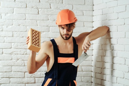 young handsome bearded macho man builder with sexy muscular athletic strong body has strong hands in...