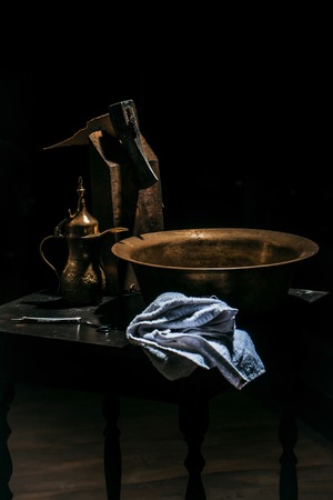 Vintage barber or shaver tools on wooden table. Old razor with blade, scissors, copper basin, water jug, axe and towel in barbershop or hairdressing saloonの写真素材