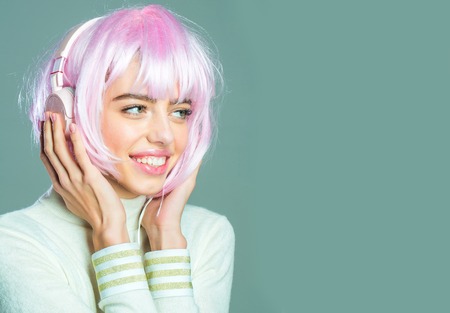 young pretty smiling woman or cute sexy girl with pink glamour hair wig in fashionable shirt, poses...