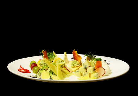 Delicious snack or platter with blue, soft, firm, aged cheese, grapes, carrot, radish, salad on plate isolated on black background. Modern molecular gastronomyの写真素材