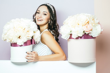 Sexy young pretty woman or cute smiling girl with crown on head, has long hair in white dress with...
