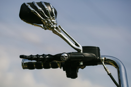 Motorbike handlebar with the mirror in skeleton design chrome metallized color on sky backgroundの写真素材