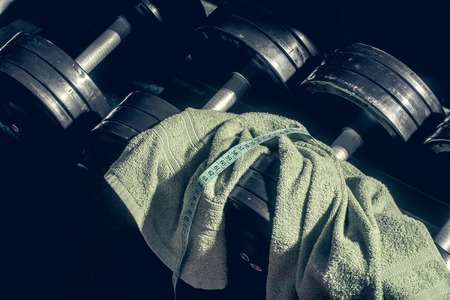 dumbbells, barbell with towel at gym for healthy training sport, weight lifting to workoutの写真素材