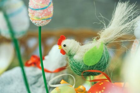 Easter decor rooster and eggs in basket on blurred backgroundの写真素材