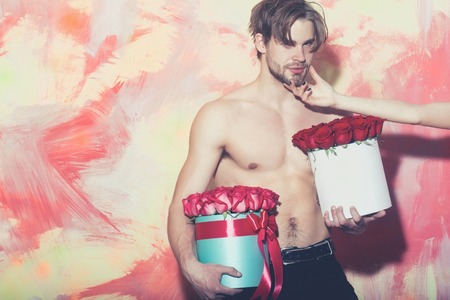 bearded macho man, brutal caucasian hipster with moustache with muscular torso, chest and body, holds red pink rose flowers in box as present on colorful background with female hand, copy spaceの写真素材