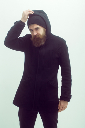 bearded man, long beard, brutal caucasian hipster with moustache on serious face, unshaven guy getting haircut by hairdresser at barbershop in black jacket, hood on white backgroundの写真素材
