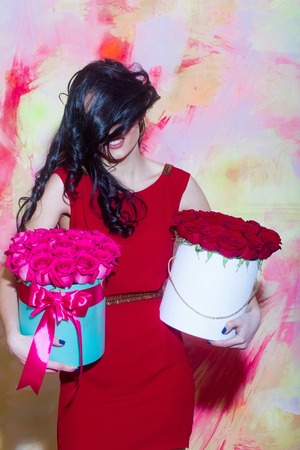 Pretty happy girl or beautiful woman with long brunette hair on face wearing red dress smiling with...