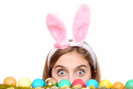 happy easter girl in pink bunny ears with colorful painted eggs on green moss and willow, has...