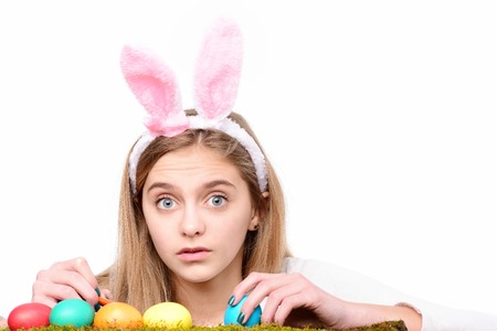 colorful painted happy easter eggs on green moss, traditional spring holiday food. girl in pink...