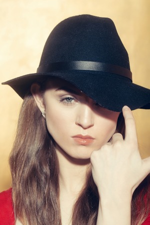 Pretty girl or beautiful fashion woman with long blond hair wearing stylish black hat and red tshirt...