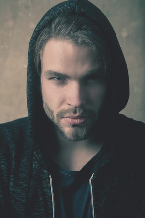 Bearded man or handsome model with stylish beard and serious face wearing fashionable, grey hoodie,...