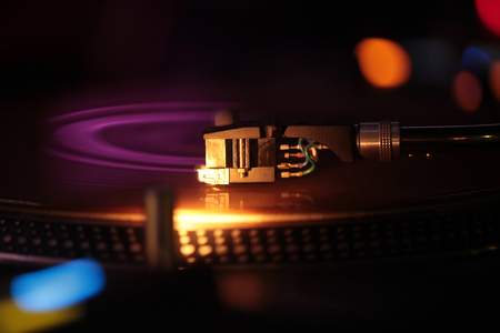 Moving pickup or audio cartridge playing on retro vinyl disc on record player or turntable,...
