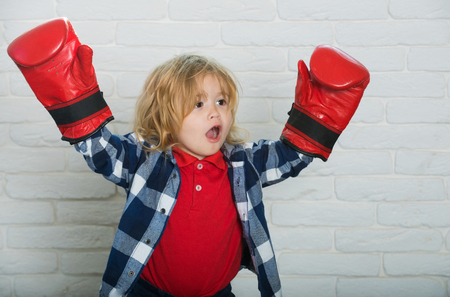 champion or happy small boy in red boxing gloves, winning poseの写真素材