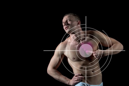 heartache of young man suffering from pain, health resolution concept, unhappy guy with bare body and pain kidney in white pants on black backgroundの写真素材