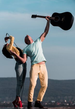 playing music band of man and woman with guitar and microphone, young group or people on festival with musical instrumentの写真素材
