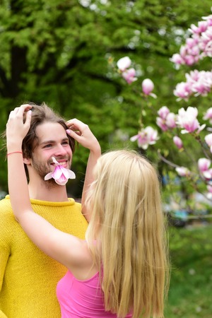 romantic couple in love in spring garden at beautiful blooming magnolia treeの写真素材