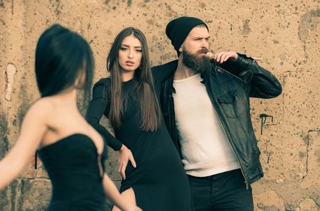 hipster man drink alcohol from glass bottle and girls smoke cigaretteの写真素材