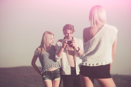 young people of man and women in summer or spring nature on blue sky background, youth, marketing and business, travel and fashion, photo cameraの写真素材