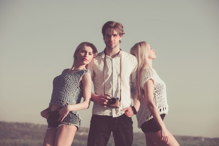 women and handsome man or photographer with camera posing on idyllic mountain landscape on sunny day on grey sky. Summer vacation. Nature. Vintage filterの写真素材