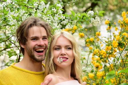 love. happy couple in love in spring cherry flowers, smiling man and girl in garden with blossom...