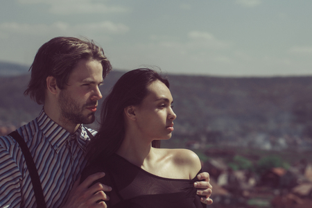 Romantic relationship, man or handsome, bearded macho, caucasian boyfriend with beard hugging adorable girl or cute woman, pretty girlfriend on sunny day on mountain top. Couple in love.の写真素材