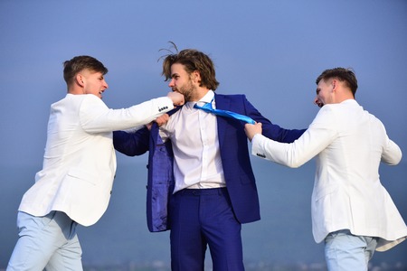 business people in formal outfit fighting on blue sky background, businessman and twin men outdoor, business conflict, conflict of interest, pressure, raidershipの写真素材