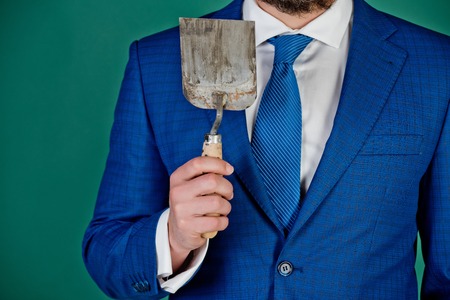 hoy tool in hand of man or businessman in blue outfit on green backgroundの写真素材