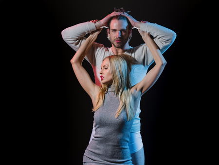 couple. couple in love, woman with pink lips, manicure and blonde hair embracing young man on black backgroundの写真素材