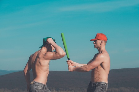 young people of men with baseball bat in hand on sky background, spring and summer nature, energyの写真素材
