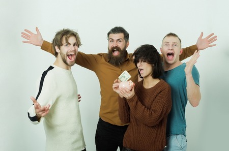 friends with moneybox. men happy shouting and cute woman or pretty girl in casual wear putting dollars money in piggy bank on white background. Savings, budget, finance, cash and friendshipの写真素材