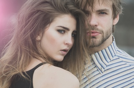 couple of heterosexual lovers on natural background. Cute girl, adorable woman, and handsome, unshaven man with fashion, stylish long hair, hairstyle enjoying time together. Love and tendernessの写真素材